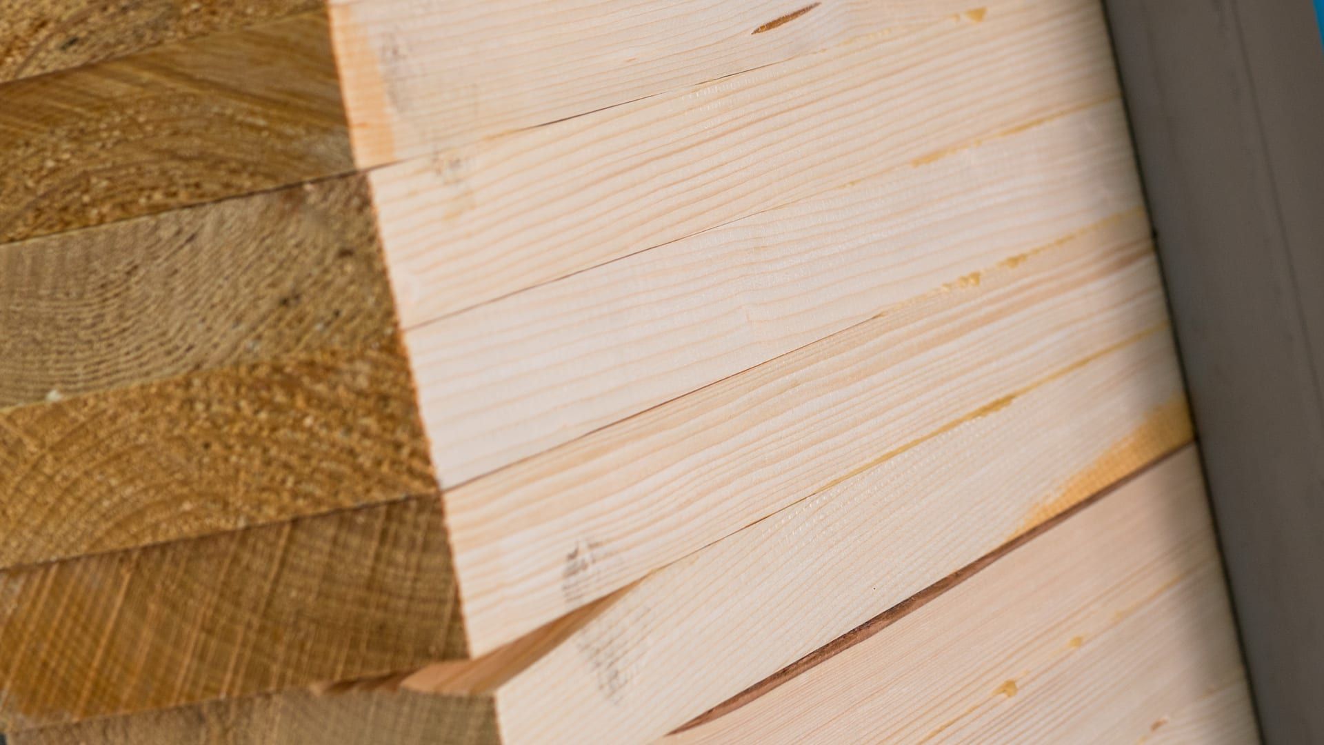 Lamas de madera encoladas y apretadas en una prensa durante la fabricación de una viga laminada